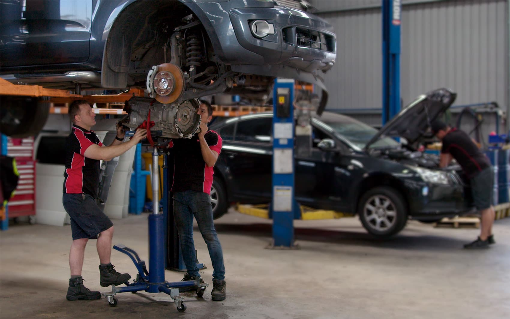 jcs parts fitting service fitting engine in car on hoist