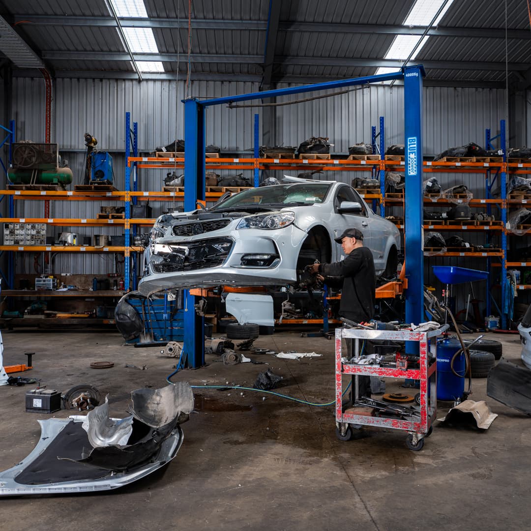 jcs parts car on hoist being dismantled